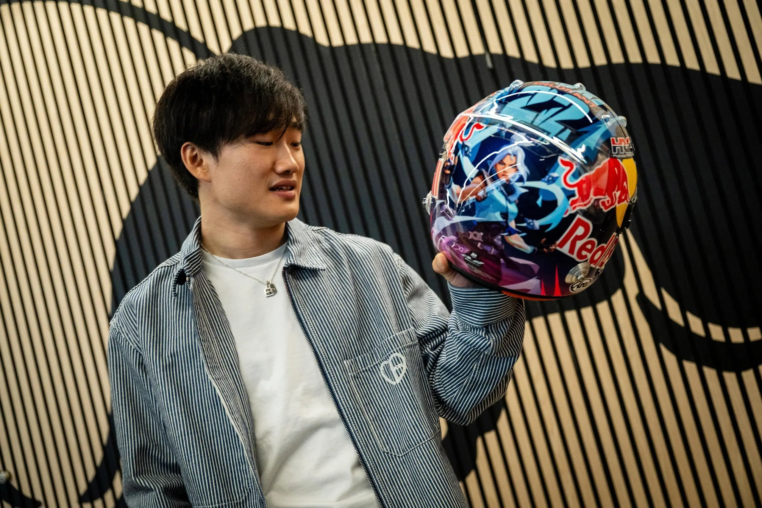 Yuki Tsunoda presents a helmet with Valorant symbols
